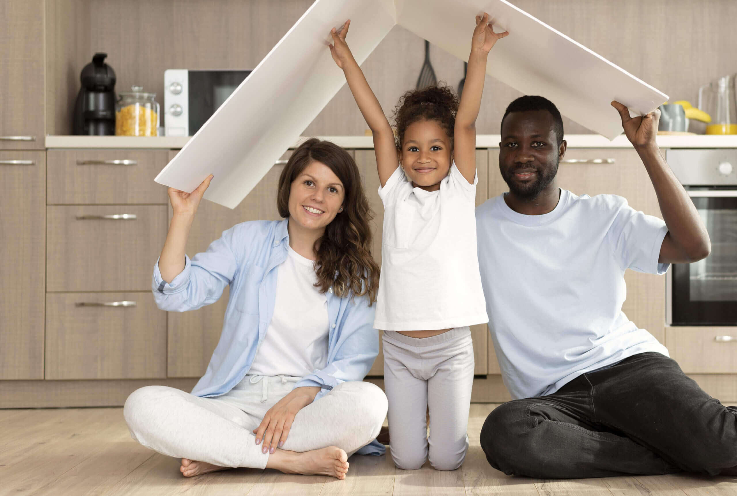 A family sitting on the floor under an open roof.