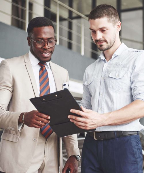 Two men standing next to each other holding a clipboard.